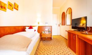 诺德奈Hotel Friese的配有一张床和一台平面电视的酒店客房