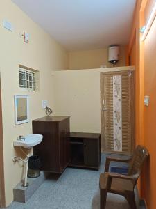 迈索尔Royal Comforts的一间带水槽、卫生间和椅子的浴室