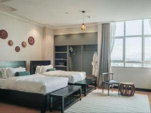 阿鲁沙Sanna Boutique Hotel的酒店客房设有两张床和窗户。