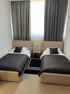 奥西耶克ZOO hotel的一间卧室设有两张床和窗户。