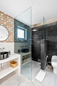 坎古Besso Villa by Hombali的一间带玻璃淋浴和卫生间的浴室