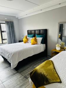 鲸湾港Euphorie的一间卧室配有两张带黄色枕头的床