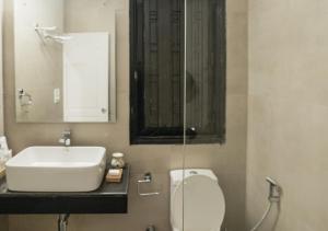 古尔冈Firebrick Boutique Residences - GARNET HOUSE的一间带水槽、卫生间和镜子的浴室