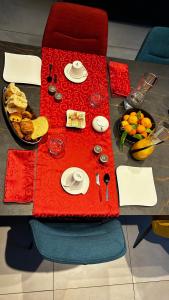 Gilly-sur-IsèreChez Chris et Gildas的一张桌子,上面有红色的桌布,上面有食物