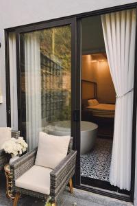 Bắc QuangCao Son Hotel的客房设有浴缸、椅子和窗户。