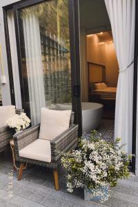 Bắc QuangCao Son Hotel的庭院设有两把椅子、浴缸和鲜花