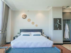 阿鲁沙Sanna Boutique Hotel的卧室配有一张大白色床,墙上挂着硬币