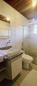 莫罗圣保罗Espaçoso apartamento a 50mt do mar的一间带水槽、卫生间和镜子的浴室