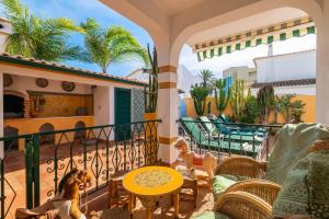 吉亚Riad Serpa Galé - Luxury, private pool, AC, wifi, 5 min from the beach的阳台的天井配有桌椅