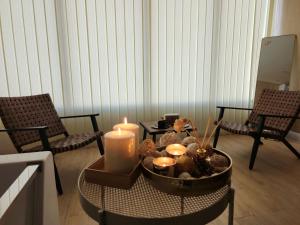 半月湾Al Qand Chalet For Families Only的客厅配有两把椅子和一张带蜡烛的桌子
