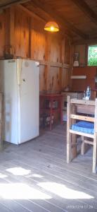 巴拉德瓦利扎斯Magavilla的小屋内的厨房配有冰箱和桌子