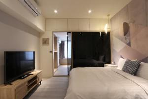 台北Sunshine Apartment的一间卧室配有一张床和一台平面电视
