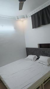 贾巴尔普尔Hotel 100 Meter的白色墙壁间的一张床位