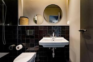 巴塞罗那Hostal Porxos Garden的一间带水槽、卫生间和镜子的浴室