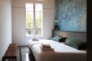 巴塞罗那Hostal Porxos Garden的带窗户的客房内的两张床