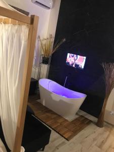 马尔萨拉Villa White Luxury Residence的一间带浴缸的浴室,墙上配有电视