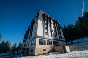 亚霍里纳Lux apartment Zlatni Javor Jahorina的蓝天下雪的建筑