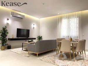 利雅德Kease Nafal C-4 Royal touch AZ46的客厅配有桌椅和电视。