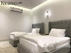 利雅德Kease Nafal C-4 Royal touch AZ46的配有白色床单的客房内的两张床
