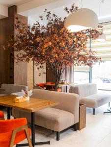 布克维Elena Spa Resort的一间设有桌子和树的用餐室
