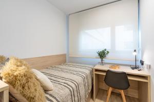 萨拉曼卡micampus Salamanca的一间卧室配有一张床和一张桌子及椅子