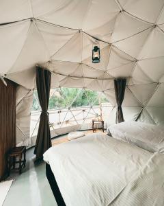 Ḩillat al ḨişnNomad inn Tiwi的一间卧室,配有带一张床和窗户的帐篷