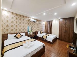 太原省Khách sạn Crown - Gần đại học Nông Lâm TN的酒店客房设有两张床和电视。