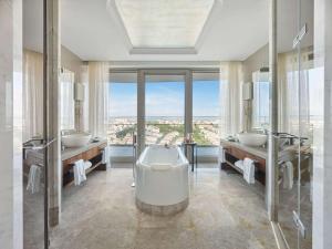 伊斯坦布尔伊斯坦布尔莱佛士酒店的浴室配有两个盥洗盆和浴缸。