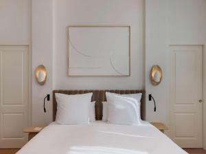 特拉维夫Elkonin Tel Aviv - MGallery Hotel Collection的卧室配有白色床和2个白色枕头