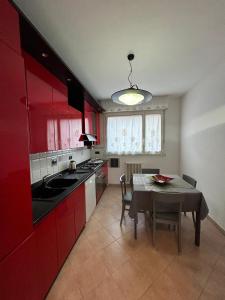 博洛尼亚Cà Savoia的厨房配有红色橱柜和桌椅