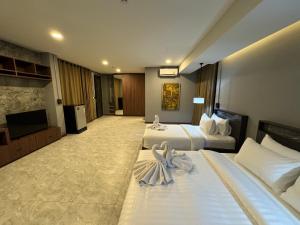 清迈Premier Hostel Chiang Mai的酒店客房设有两张床和一台平面电视。
