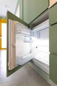 马德里Estudio moderno y acogedor en Madrid Rio nº3的空冰箱,门打开在房间里