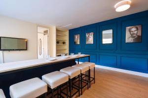 塞维利亚森特拉尔套房公寓的一间酒吧,位于一间拥有蓝色墙壁和凳子的房间