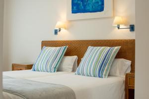 普拉亚布兰卡Apartamentos LIVVO Coloradamar的两间带条纹枕头的酒店客房