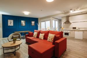 塞维利亚森特拉尔套房公寓的客厅配有红色的沙发和桌子