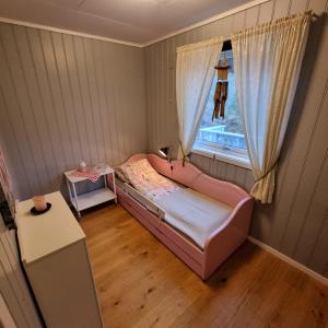 StadlandetKoselig hus med fantastisk utsikt, Stadlandet的一间小卧室,配有粉红色的床和窗户