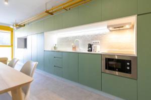 马德里Estudio moderno y acogedor en Madrid Rio nº7的一间厨房,配有绿色的橱柜和微波炉