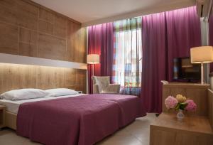 布德瓦斯洛文尼亚力士广场酒店的一间卧室配有一张紫色的床和一台电视机