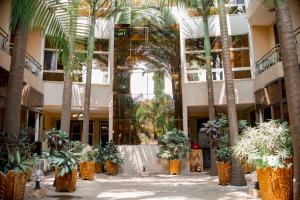 布琼布拉Tigers's apartment Hotel的棕榈树和植物的建筑中庭