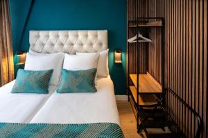 阿姆斯特丹朱庇特酒店的一间卧室配有一张带蓝色墙壁的大床