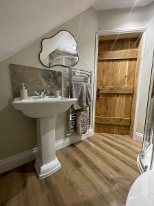 BromptonRoseberry Barn, Bullamoor, Northallerton, North Yorkshire的一间带水槽、镜子和门的浴室