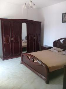 Dar el Koudiamaison à louer les grottes Bizerte Tunisie的一间卧室配有一张床和一个木制橱柜