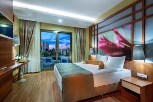阿拉尼亚Alan Xafira Deluxe Resort & Spa-ULTRA ALL INCLUSIVE的酒店客房设有一张床和一个大窗户