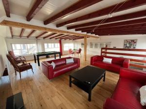 奥尔泽姆Villa avec piscine intérieure的客厅配有红色的沙发和桌子