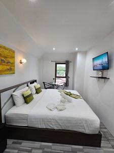 查汶苏梅岛绿色酒店的卧室配有一张白色大床,墙上配有电视