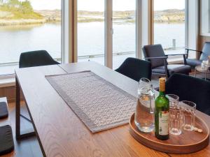 KarvågHoliday home Averøy VII的一张桌子,上面放着一瓶葡萄酒和眼镜