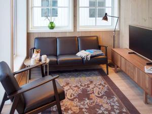 KarvågHoliday home Averøy VII的客厅配有真皮沙发和电视