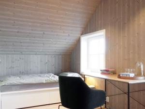 KarvågHoliday home Averøy VII的卧室配有床、椅子和窗户。