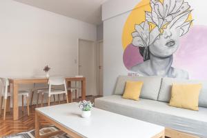 布宜诺斯艾利斯Fliphaus Esmeralda 900 - 2 Bd Calle Florida的客厅配有沙发和墙上的绘画