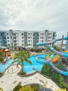 巴厘巴板Pentapolis Apartment的度假村内带水滑梯的大型游泳池
